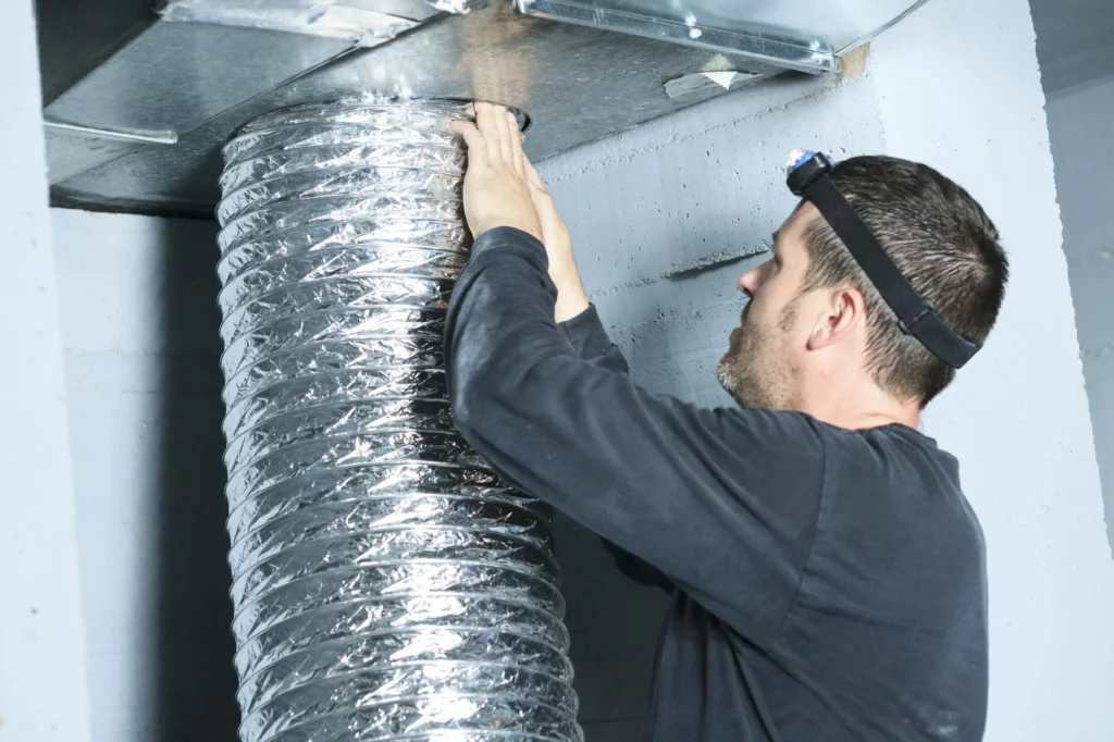 Specialist inspecting flexible ductwork for HVAC mold remediation in Charlotte, NC.
