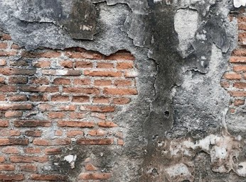 Water damaged brick wall showing moisture retention and mold growth potential.